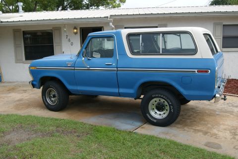 1978 Ford Bronco - This blue Ford Bronco is parked on a concrete driveway in front of a single-story house.