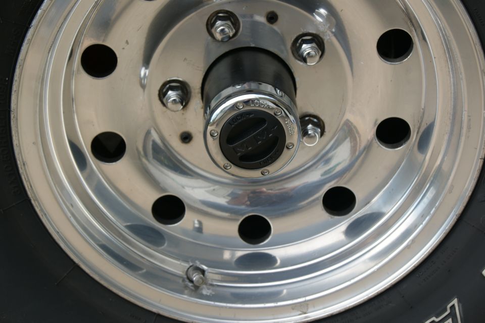 Chrome wheel with black hubcap and visible lug nuts