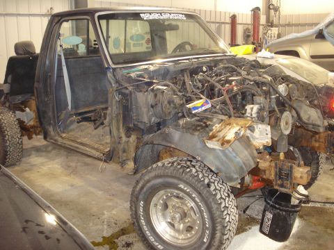 1993 Ford F-150 - Truck disassembled in a garage with engine bay stripped and doors open.