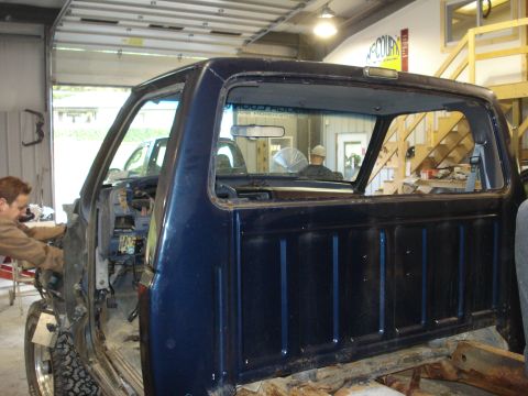 1993 Ford F-150 - A blue 1993 Ford F-150 pickup truck cab is shown in a workshop, possibly undergoing repairs or restoration.