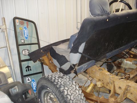 1993 Ford F-150 - The interior of a Ford truck is shown, with the door frame covered in stickers and the seat in disrepair.