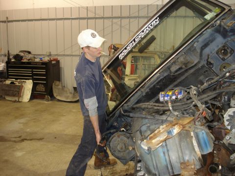 1993 Ford F-150 - A man works on the engine of a disassembled truck, revealing its internal components and wiring.