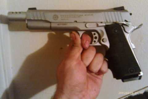 2000 Mercury Grand Marquis - A Taurus pistol is held in a hand, with text visible on the slide.