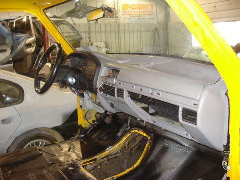 1993 Ford F-150 - Interior view of a yellow truck undergoing restoration, with parts removed from the dashboard and floor.