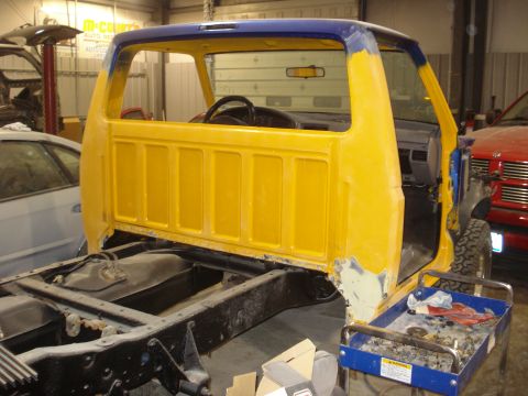 1993 Ford F-150 - A truck cab and chassis is undergoing restoration in a workshop, with another vehicle partially visible.