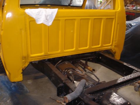 1993 Ford F-150 - The rear section of a yellow 1993 Ford F-150 cab and its frame are visible during a restoration project.