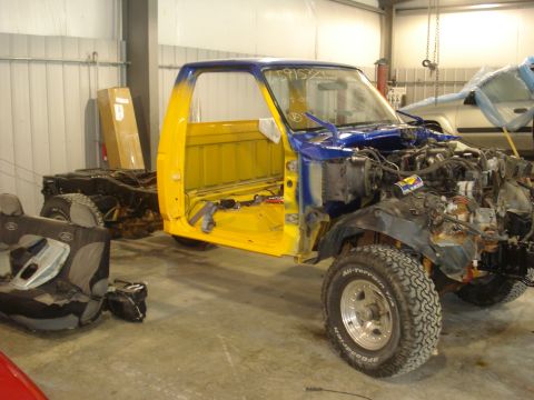 1993 Ford F-150 - A disassembled 1993 Ford F-150 pickup truck, with its cab and chassis separated, sits in a workshop.