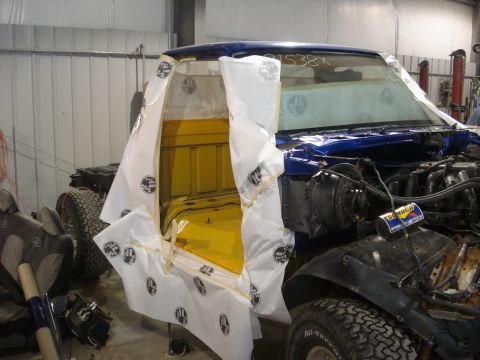 1993 Ford F-150 - A blue Ford F-150 truck cab, with its interior painted yellow, is seen in a workshop during a restoration project.