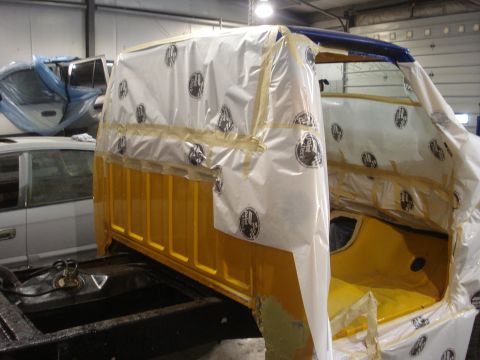 1993 Ford F-150 - Truck cab wrapped in plastic for paint prep, with another vehicle visible in the shop.