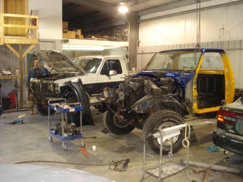 1993 Ford F-150 - Two trucks are in a garage, one is a 1993 Ford F-150 undergoing a cab-off restoration.