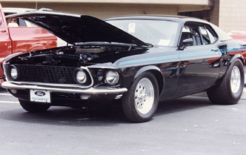 1981 Ford Bronco - This black 1969 Ford Mustang Mach 1 features racing slicks and a "Ford Motorsport" plate, with its hood open revealing the engine.