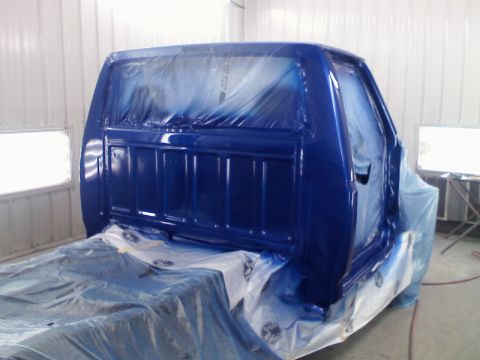 1993 Ford F-150 - Pickup truck cab undergoing a fresh coat of blue paint inside a spray booth.