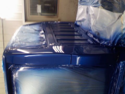 1993 Ford F-150 - The front of a blue 1993 Ford F-150 cab is covered in plastic sheeting, likely during a paint job.