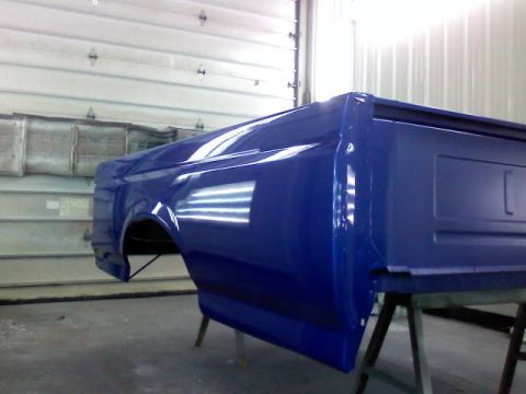 1993 Ford F-150 - A freshly painted blue truck bed is shown resting on sawhorses in a workshop.