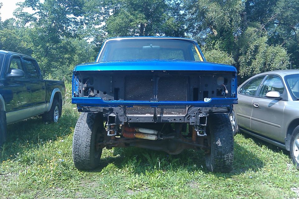 Blue 1992 Ford F-150 truck front end, missing grille and headlights, parked outdoors