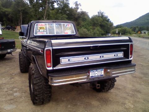1993 Ford F-150 - Rear view of a black lifted Ford pickup truck with "FORD" on the tailgate and large off-road tires.