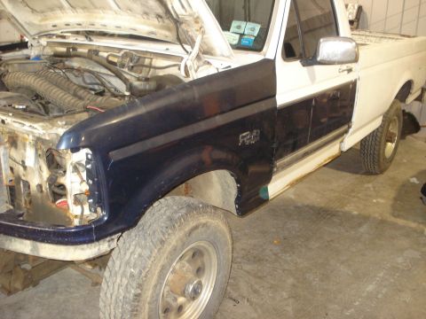 1993 Ford F-150 - This Ford F-150 truck is missing its front bumper and headlights, with the hood open.