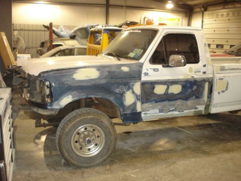 1993 Ford F-150 - A Ford F-Series truck is undergoing body repairs in a workshop, with other vehicles in the background.