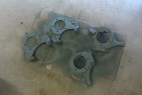 1993 Ford F-150 - Four brake caliper brackets are shown after being painted.