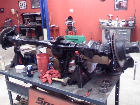 1993 Ford F-150 - A disassembled rear axle assembly sits on jack stands in a workshop environment.
