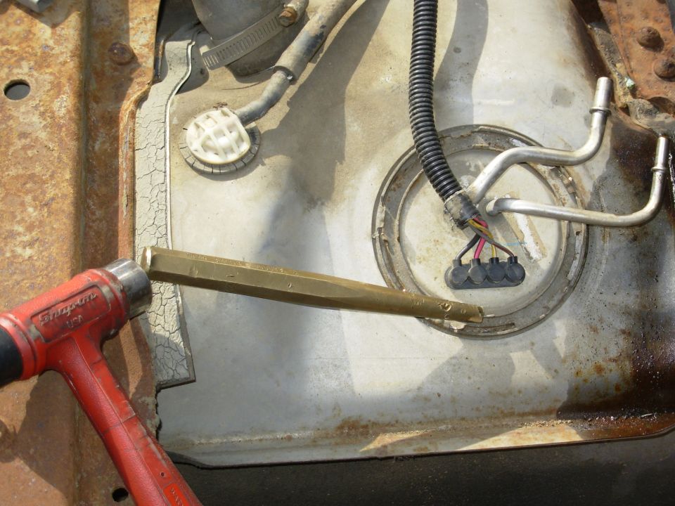 Top of a fuel tank with sending unit and a red Snap-on wrench