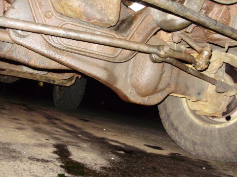 1995 Ford Bronco - Close-up view of the front axle and steering components, showing significant rust and wear.