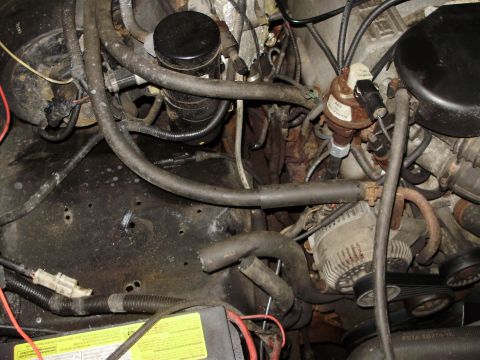 1995 Ford Bronco - Close-up view of a vehicle's engine bay, showing various components and some signs of wear.