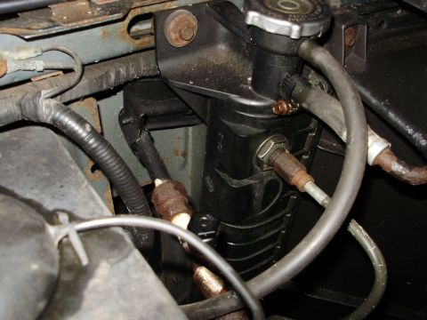 1995 Ford Bronco - The radiator overflow tank and associated hoses are shown in this close-up view of a vehicle's engine bay.