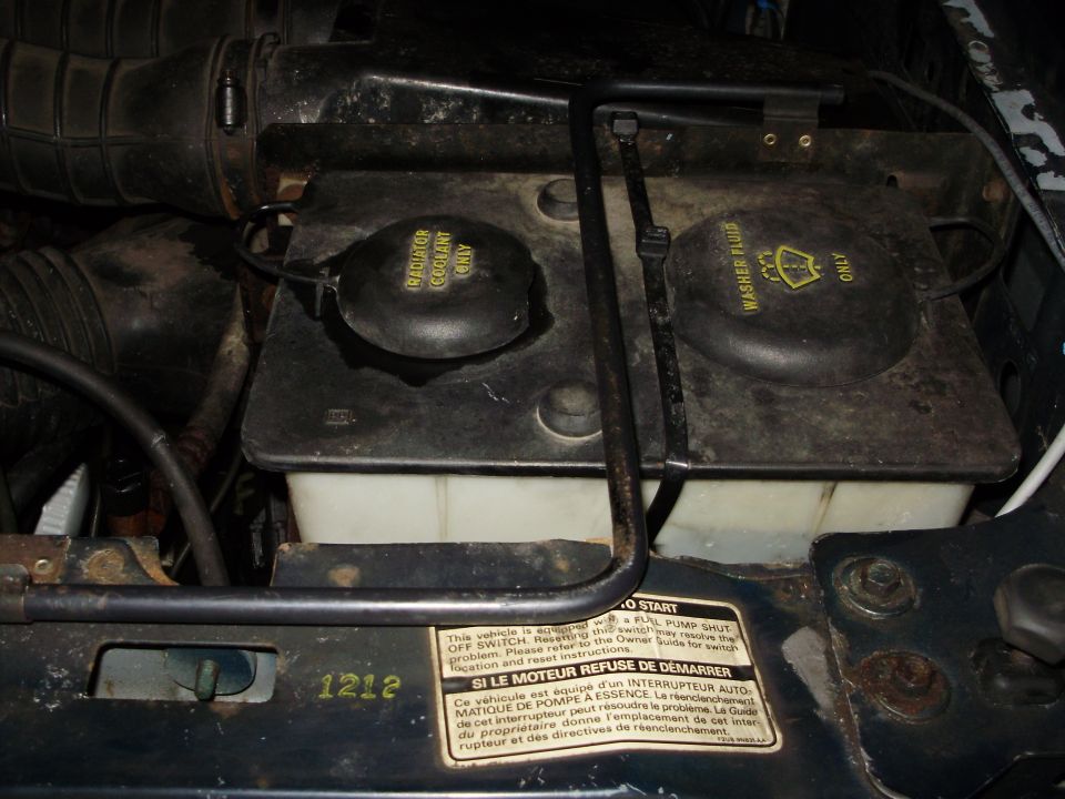 Engine bay with coolant and washer fluid reservoirs. Label reads 'SI LE MOTEUR REFUSE DE DEMARRER'