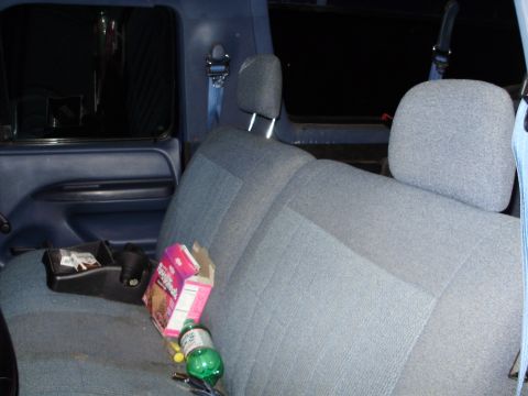 1995 Ford Bronco - The back seat of a blue truck shows a box of cookies and a soda bottle, with a Supermotors.net watermark.