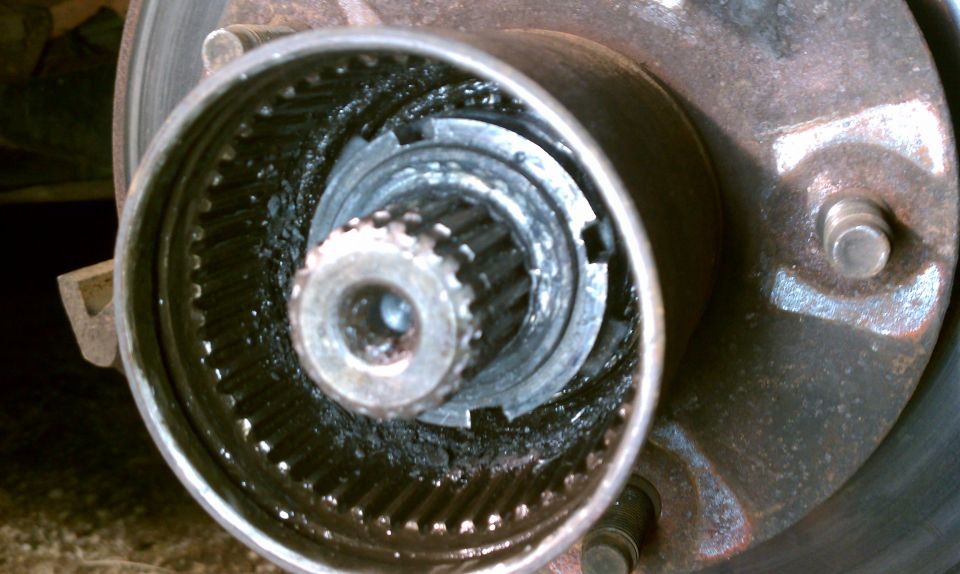 Close-up of a vehicle's front hub assembly with visible splines and grease