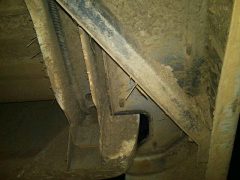 1995 Ford F-150 - The underside of a vehicle shows a heavily soiled frame with various metal components and a protective wire conduit.