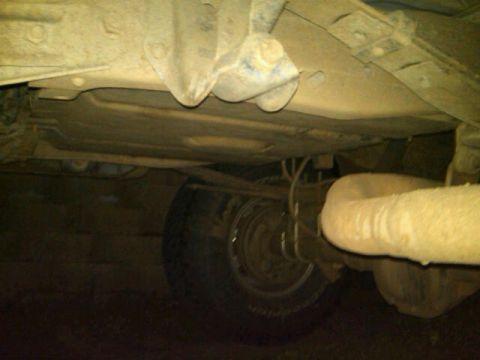 1995 Ford F-150 - The underside of a vehicle is visible, including a tire and exhaust system.