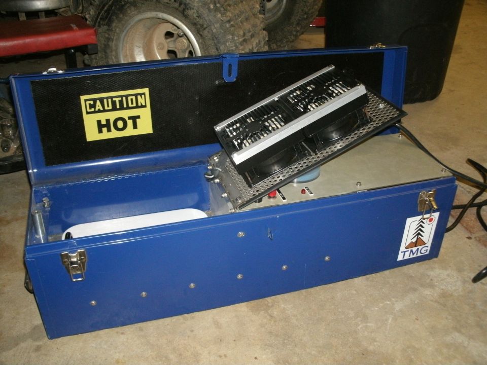 Open blue toolbox with a "CAUTION HOT" sticker inside and a fan unit. A Supermotors.net logo is visible