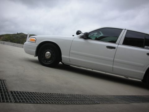 2004 Ford Crown Victoria - Side view of a white 2004 Ford Crown Victoria parked on a concrete surface.