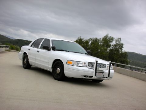 2004 Ford Crown Victoria - Front 3/4 view of a white 2004 Ford Crown Victoria police car with a push bumper.