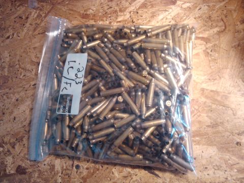 1989 Ford Bronco - Bag of spent .303 LC/FC rifle cartridges on a wooden surface.