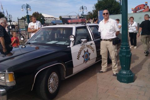 1991 Ford LTD Crown Victoria - A man stands next to a 1991 Ford Crown Victoria police car with "HIGHWAY PATROL" text on the door.