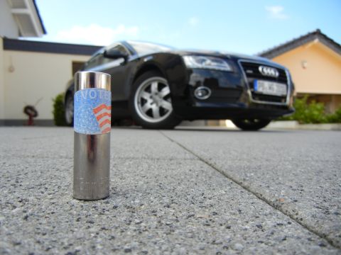 2010 Audi A4 - A black Audi sedan is parked in front of a house, with a vote sticker on a metal cylinder in the foreground.