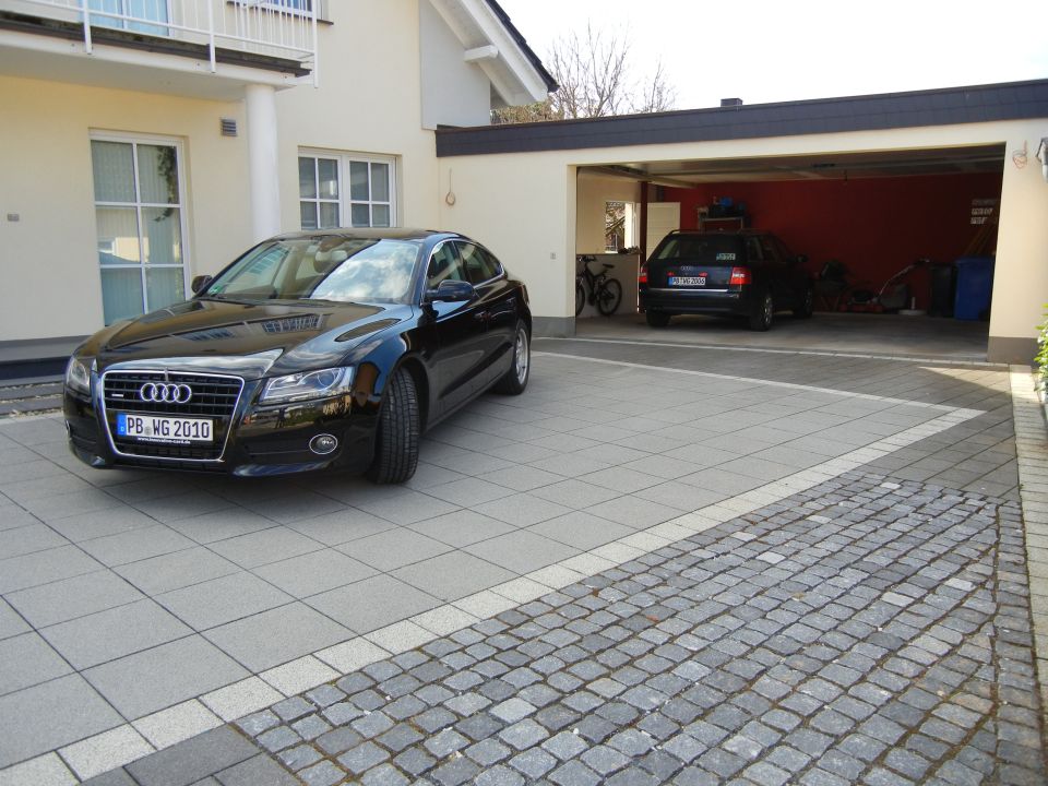 Black Audi sedan with license plate PB WG 2010 parked on a paved driveway