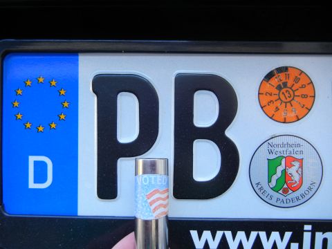2010 Audi A4 - A close-up of a German license plate shows official stickers and a "VOTED" sticker on a cylindrical object.