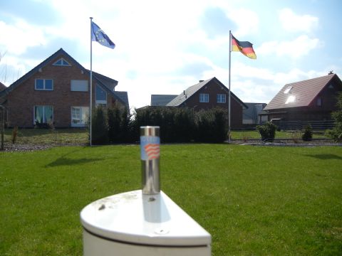 1999 Lincoln Town Car - A close-up of a metallic object with an American flag design sits in a grassy yard with houses and flags in the distance.