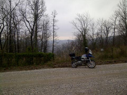 2001 BMW R1150GS ABS - Motorcycle parked on a gravel road with a wooded hillside behind it.