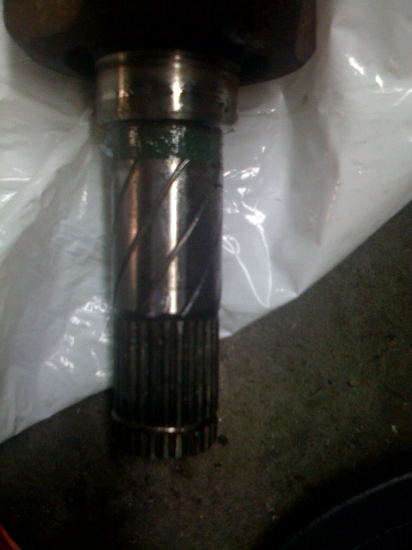 Close-up of splined transmission output stub shaft with bearing journal and green paint band