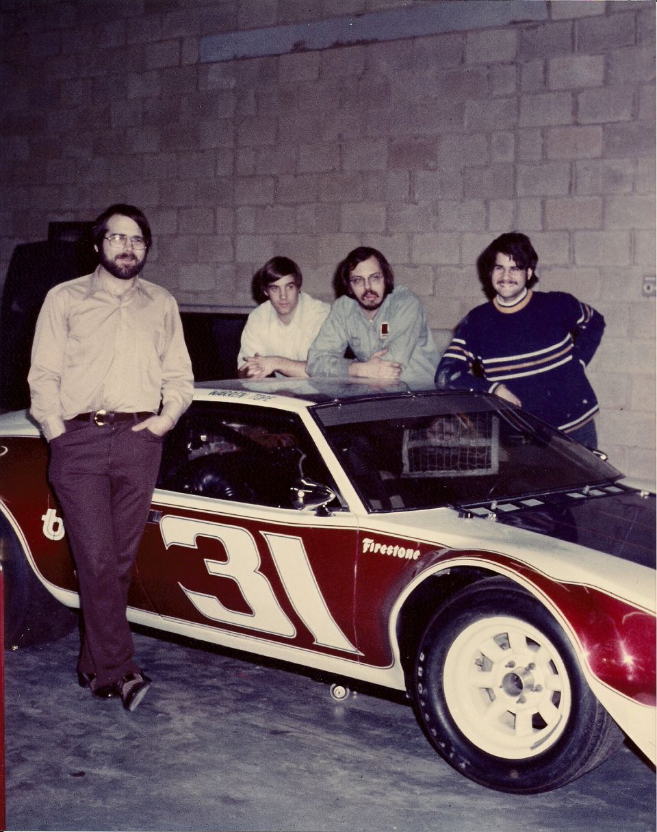 1973 Ford Mustang race car with number 31 and Firestone tires, four men standing around it