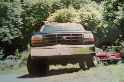 1993 Ford F-150 - Frontal view of a 1992 Ford F-150 pickup truck parked outdoors with a red car in the background.