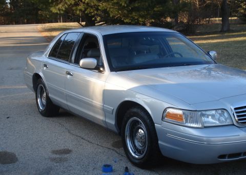 2000 Ford Crown Victoria - This silver 2000 Ford Crown Victoria sedan is shown from a 3/4 front angle, parked outdoors on a paved surface.