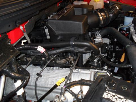 2011 Ford F-150 - The engine bay of a 2011 Ford F-150 shows Shelby Ford valve covers and various engine components.