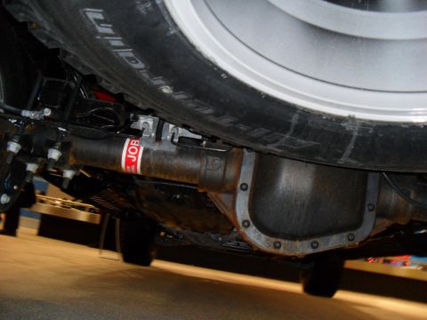2011 Ford F-150 - Underside view of a vehicle's rear axle and tire, showing the differential and a red sticker on the axle.