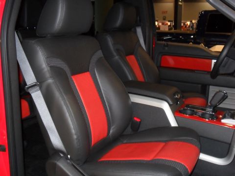 2011 Ford F-150 - The interior of a truck features black leather seats with red accents and a gray seatbelt.